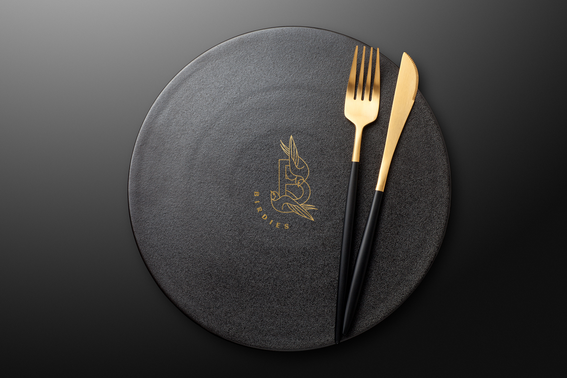 Fork and knife on a empty  black plate. Top view.